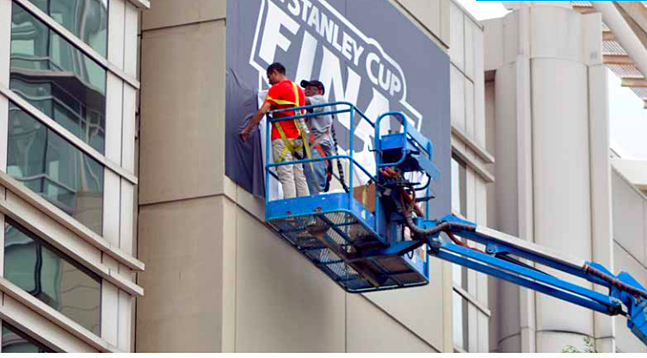 Crew hanging a Stanley Cup Final 2018 Banner